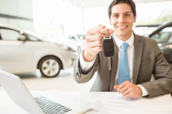 Vendedor segurando chave do carro do cliente — Fotografia de Stock