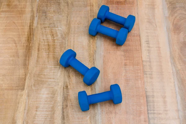 Dumbbells on wooden table — Stock Photo, Image