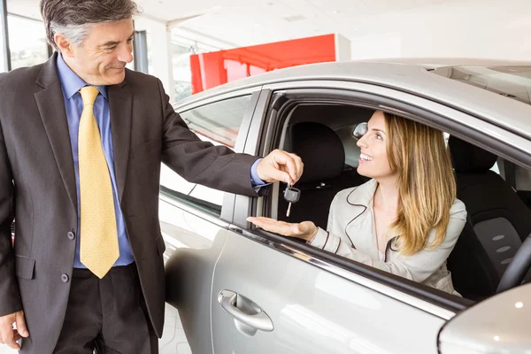 Vendeur offrant la clé de voiture à un client — Photo