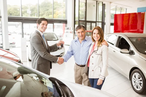 Salesman giving car key to a couple — Stock Photo, Image