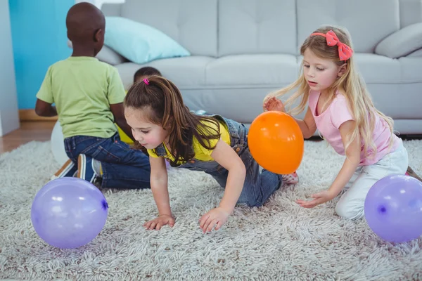 Glückliche Kinder spielen mit Luftballons — Stockfoto