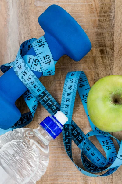 Apple, measuring tape and dumbbell — Stock Photo, Image