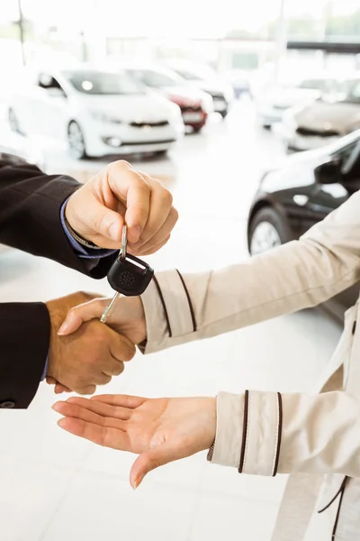Πωλητής προσφέροντας αυτοκίνητο κλειδί στους πελάτες — Φωτογραφία Αρχείου