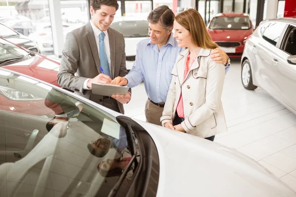 Empresário sorridente apresentando um carro — Fotografia de Stock