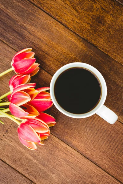 Κόκκινα λουλούδια και το φλιτζάνι του καφέ — Φωτογραφία Αρχείου