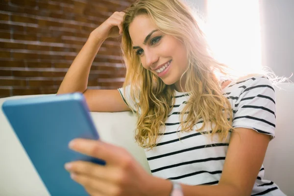 Pretty blonde using tablet on couch — Stock Photo, Image
