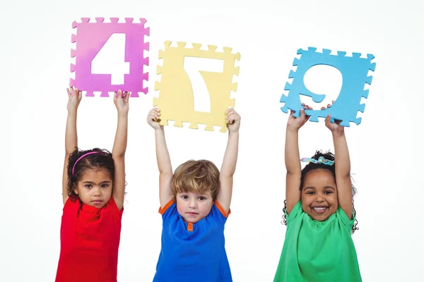 Three kids holding number shanpes above their heads — Stock Photo, Image