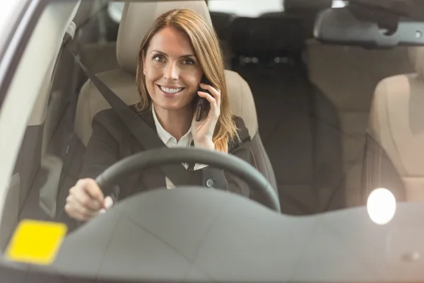 Affärskvinna med ett telefonsamtal som sitter i bilen — Stockfoto