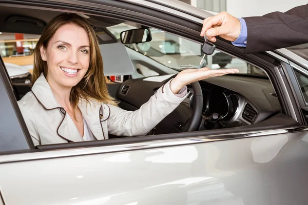 Salesman offering car key to a customers — Stock Photo, Image