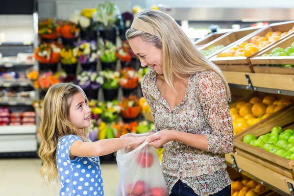 Lachende moeder en dochter plukken van apple — Stockfoto