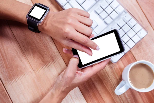 Feminine hands with smartwatch using smartphone — Stock Photo, Image