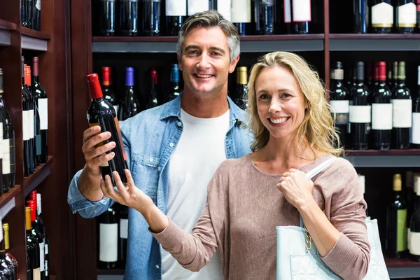 Χαμογελώντας ζευγάρι με μπουκάλι κρασί — Φωτογραφία Αρχείου