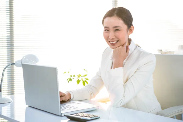 Lächelnde Geschäftsfrau mit ihrem Laptop — Stockfoto