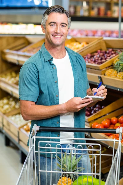 Hombre sonriente mirando su lista —  Fotos de Stock