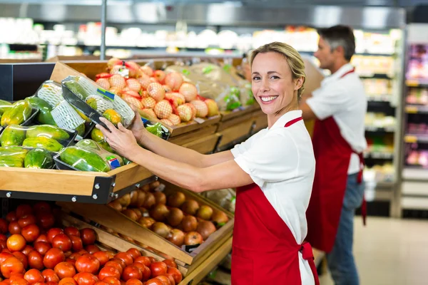 Mulher sorridente enchendo caixas de legumes — Fotografia de Stock