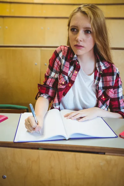 Сосредоточенный студент делает заметки во время занятий — стоковое фото