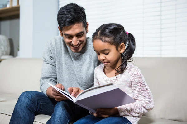 Feliz padre e hija usando el portátil en el sofá — Foto de Stock