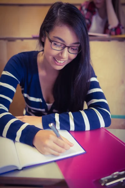 Estudante sorrindo escrevendo no caderno — Fotografia de Stock
