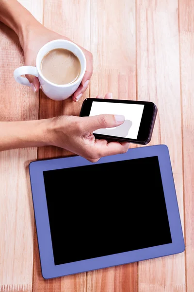 Femme d'affaires tenant smartphone et tasse de café — Photo