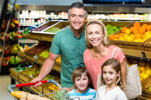 Jonge familie poseren samen met trolley koffer — Stockfoto