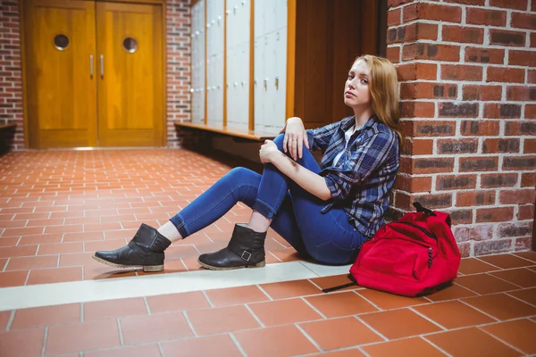 Orolig student sitter på golvet mot väggen — Stockfoto