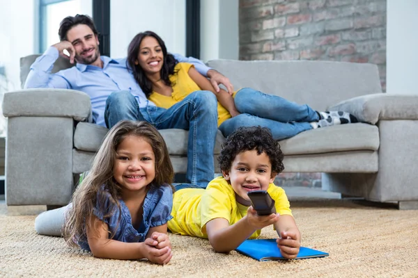 Sonriente familia en la sala de estar mirando tv — Foto de Stock