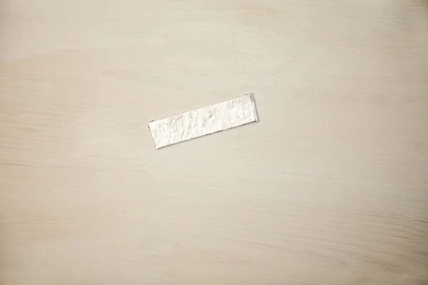 Chewing gum wrapper on wooden desk — Stock Photo, Image