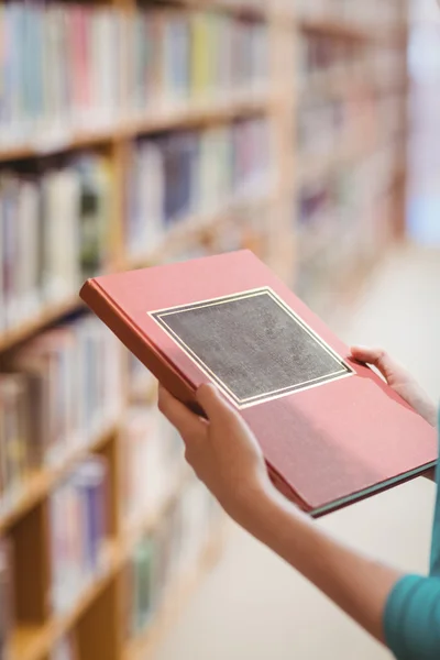Над видом на плече студента в бібліотеці тримає книгу — стокове фото