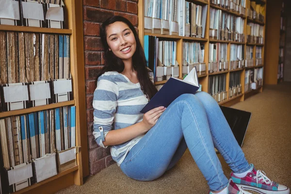 Усміхнений студент сидить на підлозі — стокове фото