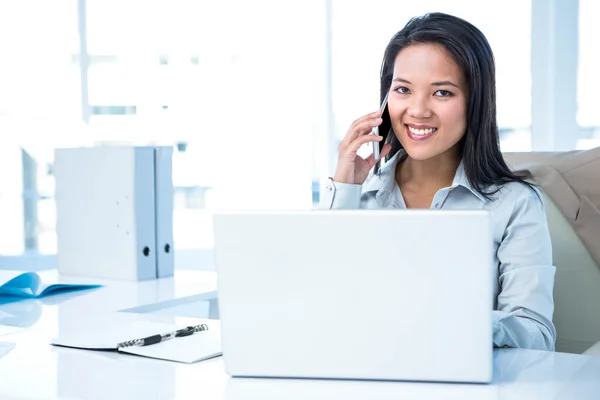 Smiling businesswoman phoning at the desk — Stock Photo, Image