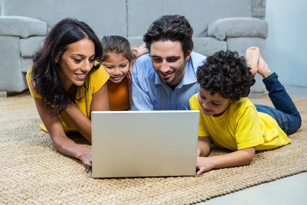 微笑着家人在客厅里使用笔记本电脑 — 图库照片