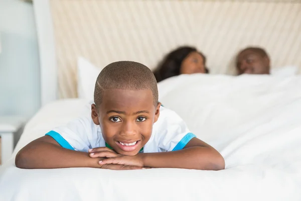 Lächelnder Sohn liegt auf dem Bett — Stockfoto