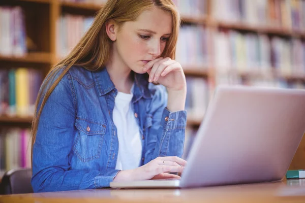 Fókuszált hallgató használ laptop-könyvtár — Stock Fotó