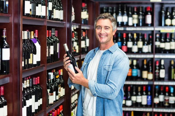 Χαμογελαστός άνθρωπος που κρατά το μπουκάλι κρασί — Φωτογραφία Αρχείου