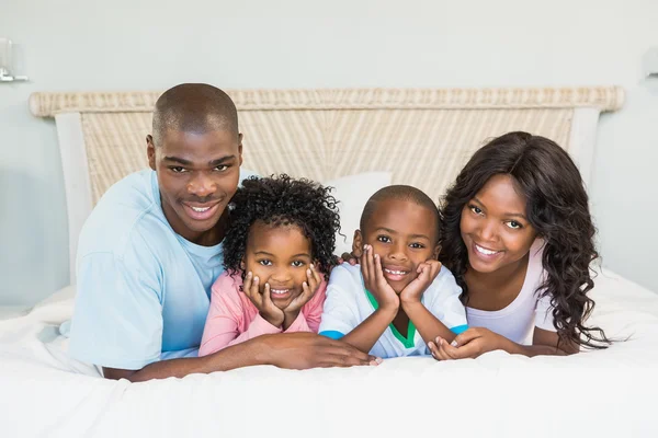 Šťastná rodina, ležící na posteli — Stock fotografie