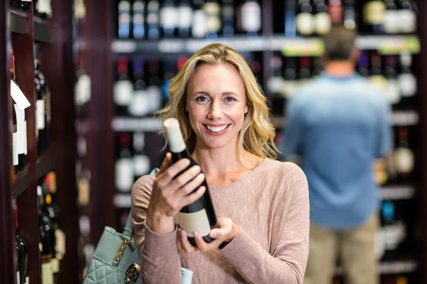 Mosolygó nő gazdaság üveg bor — Stock Fotó