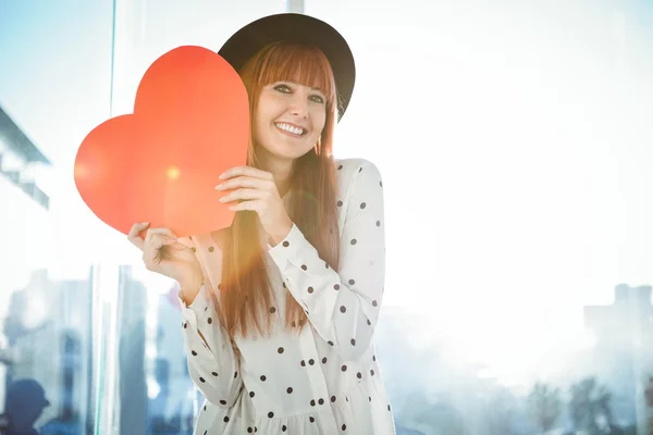 Attraente donna hipster dietro un cuore rosso — Foto Stock