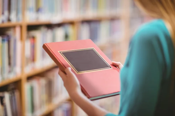 Öğrenci kitaplığı holding kitapta omuz görünümü üzerinde — Stok fotoğraf
