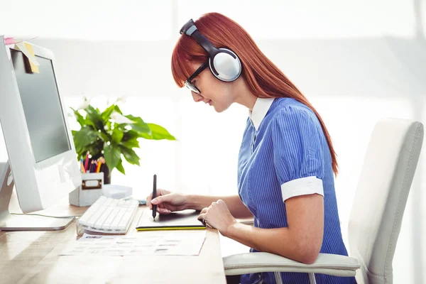 Attraente donna hipster con auricolare utilizzando tablet grafica — Foto Stock