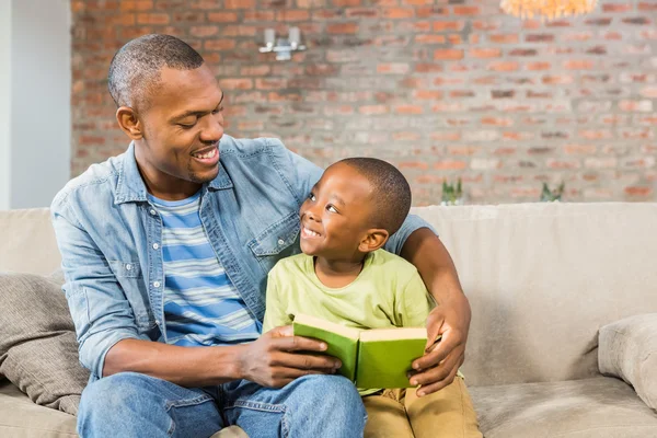 Padre e figlio che leggono sul divano — Foto Stock