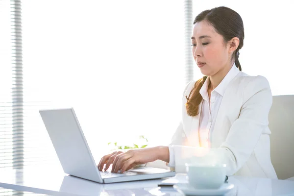 Mujer de negocios seria usando el ordenador portátil —  Fotos de Stock