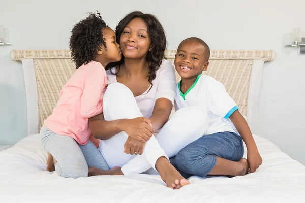 Moeder en kinderen zittend op bed — Stockfoto