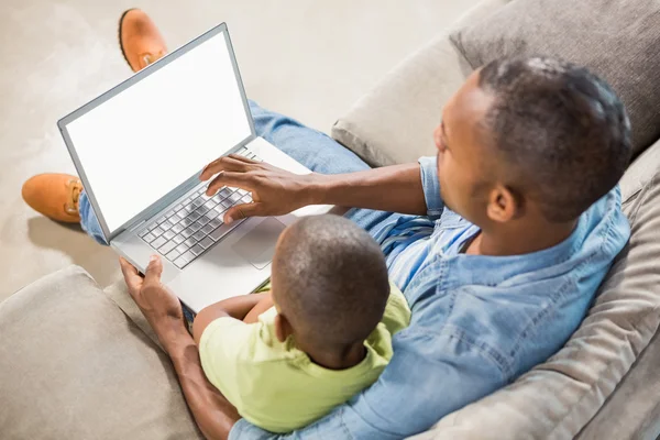 父亲和儿子在沙发上使用笔记本电脑 — 图库照片