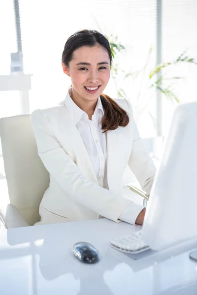 Sorrindo empresária usando seu computador — Fotografia de Stock