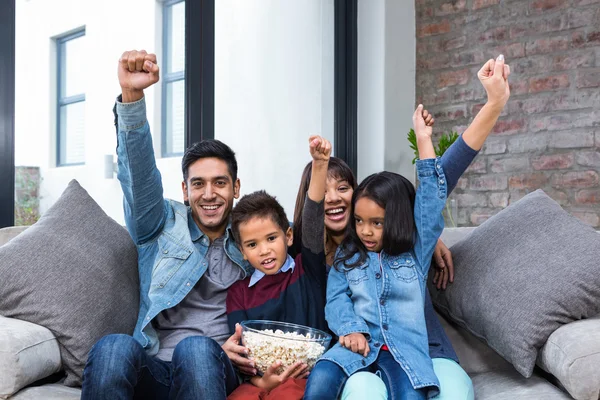 Tv를 보면서 팝콘을 먹는 행복 한 젊은 가족 — 스톡 사진