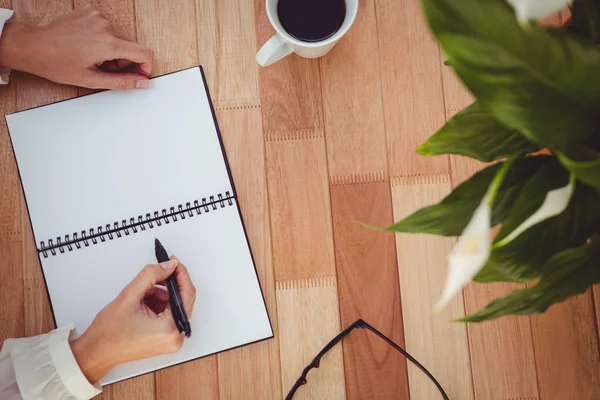 Cropped image of woman writing on notepad — Stock Photo, Image