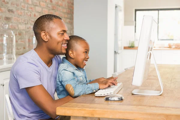 Sevimli oğlu baba ile masada dizüstü bilgisayar kullanarak — Stok fotoğraf