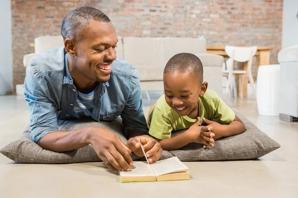 Padre e figlio che leggono sul pavimento — Foto Stock