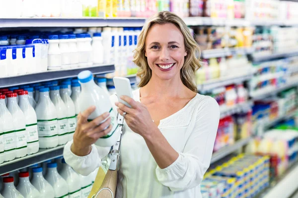 Krásná žena vyfotit láhev mléka — Stock fotografie