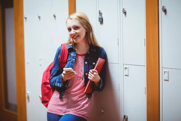 Bonita estudiante con mochila apoyada en el casillero — Foto de Stock